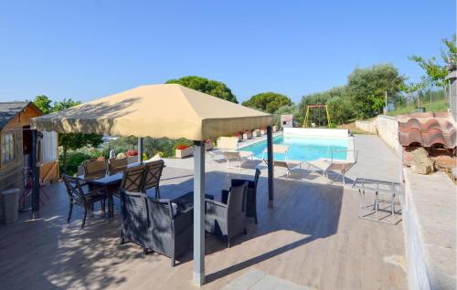 a table and chairs under an umbrella next to a pool at Amazing Apartment In Magione in Magione