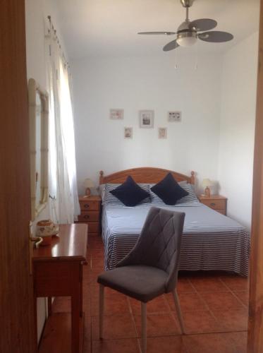 a bedroom with a bed and a chair and a table at Casa Ramona in Valencia