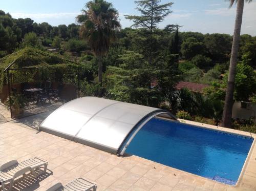 a white swimming pool with chairs and trees at Casa Ramona in Valencia