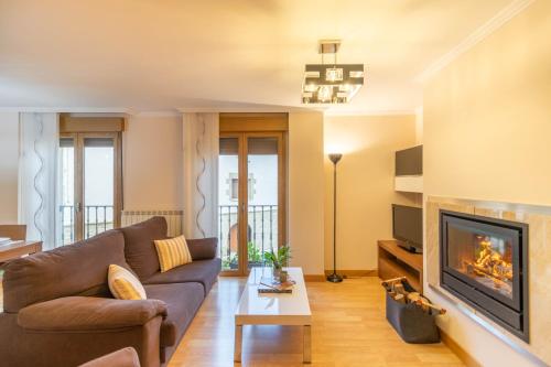 a living room with a couch and a fireplace at Acogedor apartamento rodeado de naturaleza in Lerate