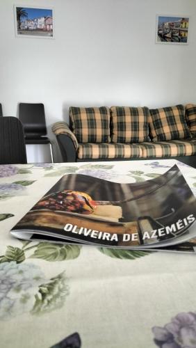 a table with a magazine on it with a couch at Casa T3 Área Metropolitana do Porto in Carregosa
