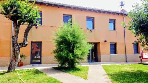 an orange building with a tree in front of it at CASA LA VILLA in Villamartín de Don Sancho
