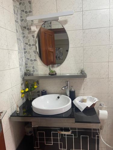 a bathroom with a sink and a mirror at OSIF Chic City Retreat in Yaoundé