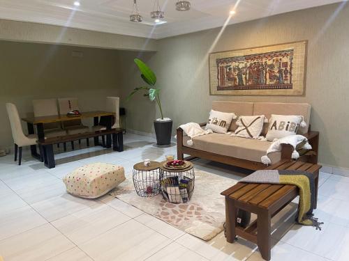 a living room with a couch and a piano at OSIF Chic City Retreat in Yaoundé
