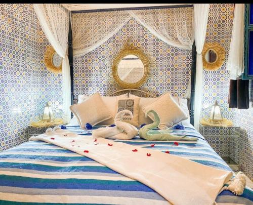 a bedroom with a bed with two swans on it at riad la citadelle in El Jadida