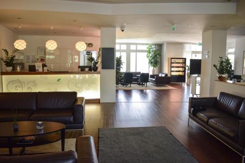 a living room with leather couches and a bar at Landhotel Rügheim in Rügheim