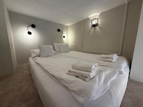 a white bed with white sheets and towels on it at ROOSEVELTA RESIDENCE Apartments - przy OFF Piotrkowska in Łódź