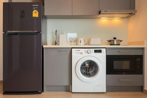una cucina con lavatrice e frigorifero di BTS Thonglor Skyline Condo a Bangkok