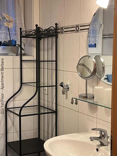 a bathroom with a glass shelf next to a sink at Ferienwohnung Barbara in Oberammergau