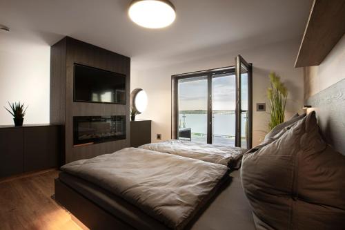 a bedroom with a bed and a large window at Ferienhaus SUNFLOWER am Hainer See in Kahnsdorf