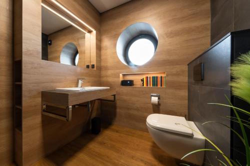 a bathroom with a sink and a toilet and a mirror at Ferienhaus SUNFLOWER am Hainer See in Kahnsdorf