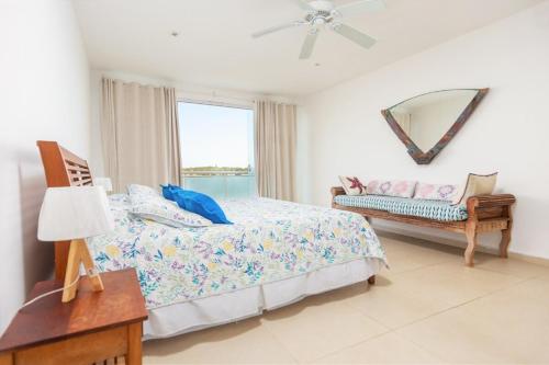 une chambre avec un lit, un miroir et une fenêtre dans l'établissement casa mar pé na areia, à Búzios