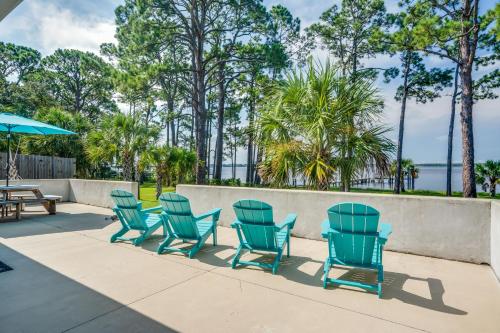 a group of blue chairs and a table and umbrella at Private Beach and Dock Waterfront Panacea Retreat! in Panacea