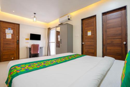 a bedroom with a white bed with a colorful blanket on it at Itsy Hotels Metro in Pune