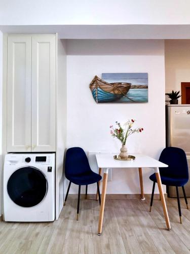 a kitchen with a table and a washing machine at Antonia's Apartments in Archangelos