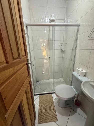 a bathroom with a shower and a toilet and a sink at Suites da praia in Abraão