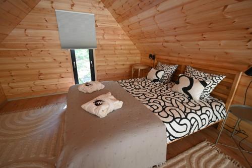 a bedroom with a bed in a log cabin at Oaklounge Apartman in Kismaros