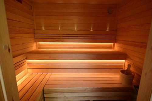 a wooden sauna with a wooden floor and a tub at Oaklounge Apartman in Kismaros