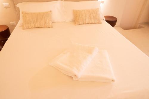 a white bed with white sheets and pillows at Tinè Bed & Relax in Gioia del Colle