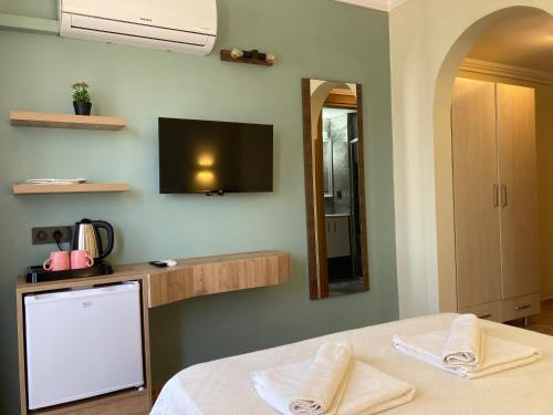 a bedroom with a bed and a tv on the wall at Olimpia Hotel in Fethiye