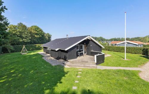 a small black house in a grassy yard at Cozy Home In Sydals With Sauna in Sarup