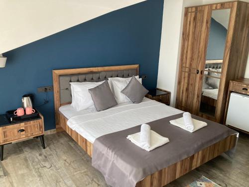 a bedroom with a large bed with two towels on it at Olimpia Hotel in Fethiye