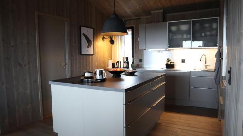 a kitchen with white cabinets and a black counter top at Levehytta - cabin with a view at 1000 masl in Ål