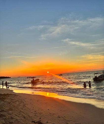 a group of people on the beach at sunset at Sr Perú Baru in Polonia