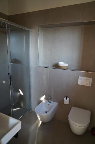 a bathroom with a shower and a toilet and a sink at Villa Andrea in Rodello