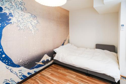 a bedroom with a large painting on the wall at Chichibu Nostalgia ちちぶの情景 in Chichibu