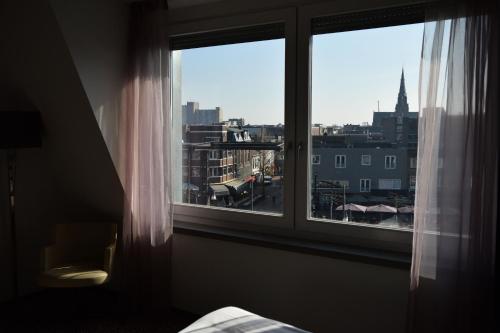 a bedroom window with a view of a city at Villa Rubenshof in Helmond