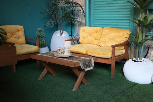 a living room with two chairs and a coffee table at האבן והים - סוויטה מהממת עם ג'קוזי בעיר העתיקה עכו in ‘Akko