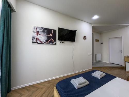 a bedroom with a bed and a tv on a wall at Deluxe Rooms and Apartments Near Metro in Tbilisi City