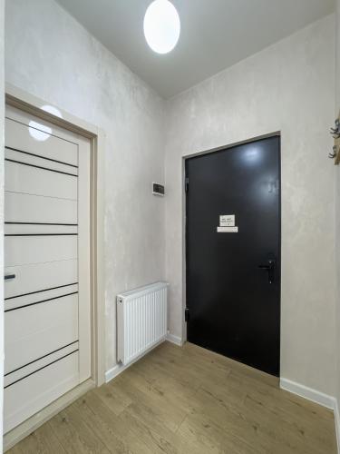 a large black door in a room with wooden floors at Deluxe Rooms and Apartments Near Metro in Tbilisi City