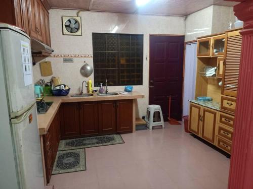 a kitchen with a refrigerator and a sink in it at TMS Homestay in Kangar