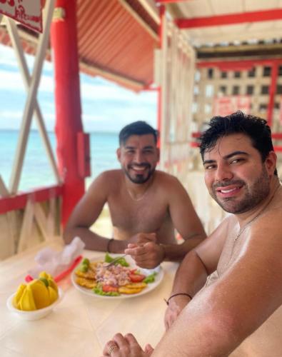two men sitting at a table with a plate of food at Sr Perú Baru in Polonia