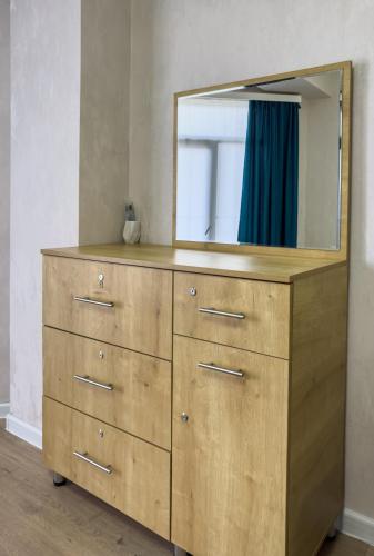 a wooden dresser with a mirror on top of it at Deluxe Rooms and Apartments Near Metro in Tbilisi City