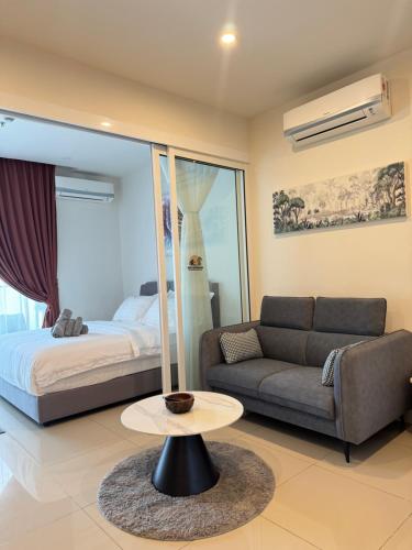 a living room with a couch and a bed and a table at The Shore Kota Kinabalu by Ems Executive Suites Seaview in Kota Kinabalu