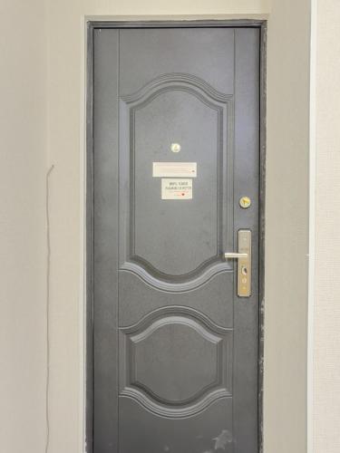 a grey door with a sign on it at Deluxe Rooms and Apartments Near Metro in Tbilisi City