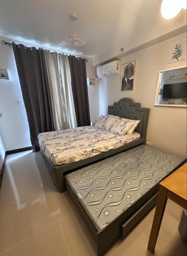 a bedroom with two beds and a table at J&A Arcadia in Lapu Lapu City