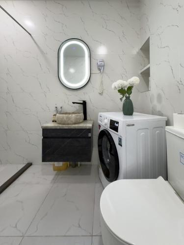 a white bathroom with a washing machine and a sink at Shirin And Cozy Apartment With Jacuzzi Balcony in Tbilisi City