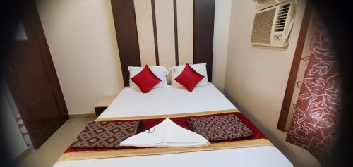 ポラチーにあるHotel BMR Stayのベッドルーム1室(赤と白の枕が備わるベッド1台付)