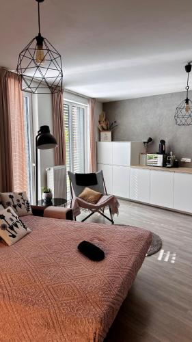 a bedroom with a bed and a chair in it at Jezerní apartmán s terasou a saunou v Lakepark Residence in Doksy