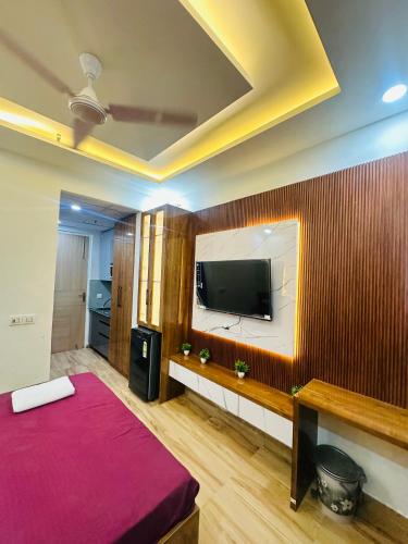 a room with a bed and a flat screen tv at The Azure1 in Greater Noida