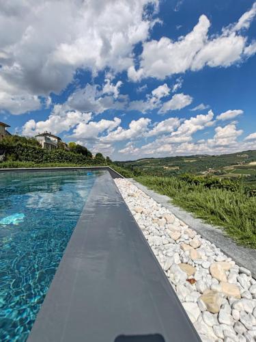 a swimming pool with blue water and rocks at Villa Andrea in Rodello