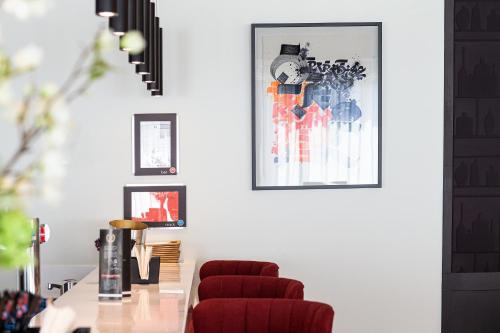 a dining room with a table and two red chairs at OSKO Hôtel Toulouse Aéroport in Blagnac