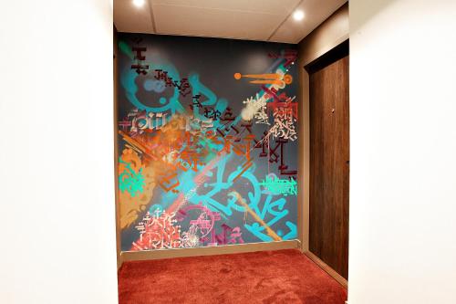 a room with a wall covered in graffiti at OSKO Hôtel Toulouse Aéroport in Blagnac