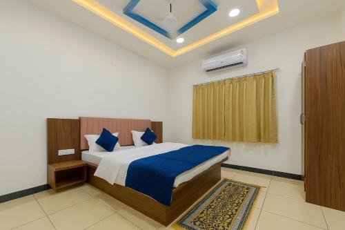 a bedroom with a bed with blue sheets and a window at Bp lake view in Udaipur