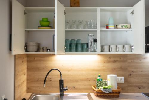 a kitchen with white cabinets and a sink at Zum Ratsdiener mit Parkplatz in Wernigerode