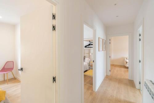 a room with white walls and a hallway with a mirror at Acogedora casa para familias a 15 min de Bardenas in Fustiñana